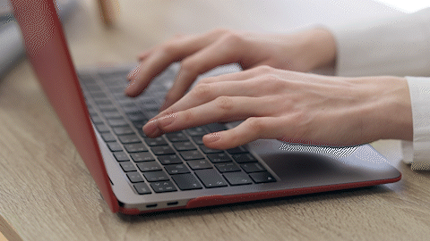 Description of video. A pair of hands typing on a laptop computer.